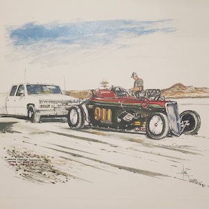 Op de afbeelding: Een aquarel van een rode en zwarte raceauto met het nummer 911 aan de zijkant. De auto wordt gesleept door een witte pick-up truck op een wit, zanderig oppervlak. De auto heeft een bestuurder in de cockpit en een persoon staat op de grond naast de auto. De aquarel is gesigneerd door de kunstenaar, Hal Jackson, en gedateerd 1989.