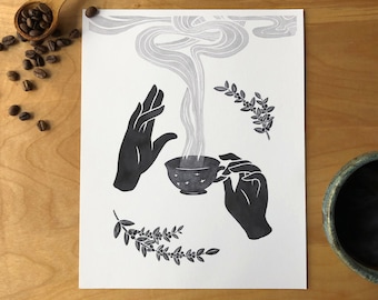 以下が含まれることがあります： 2 つの手に、湯気の立つコーヒーカップが描かれた白黒のイラスト。カップには星形の模様があり、スタイリッシュな煙と葉で囲まれています。