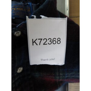May include: A dark plaid button-down shirt featuring a Pendleton brand label at the collar. A white rectangular tag is attached to the front, displaying the alphanumeric code K72368 and the text Thank you! in black ink.