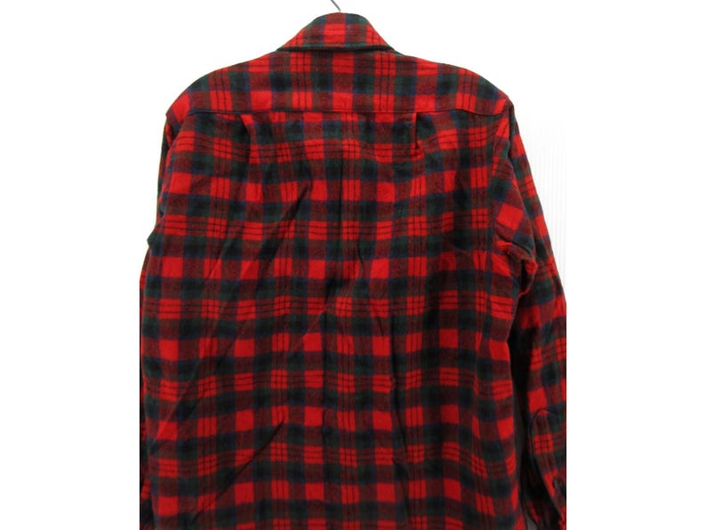 Puede incluir: Una camisa de manga larga con botones que presenta un patr&oacute;n de cuadros cl&aacute;sico en rojo y negro. La prenda tiene un cuello est&aacute;ndar, un canes&uacute; en la espalda y un cierre frontal de botones, con un dise&ntilde;o de cuadros uniforme en toda la tela.