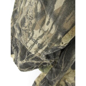 Puede incluir: Primer plano de una tela de camuflaje. La tela presenta una mezcla de tonos verdes, marrones y beige, creando un dise&ntilde;o naturalista. La palabra "BEARUP" es visible en la tela.