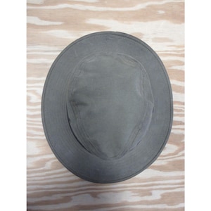 Op de afbeelding: Een grijze hoed met brede rand en een ronde kroon. De hoed is gemaakt van een duurzame stof en heeft een eenvoudig, klassiek ontwerp. De rand van de hoed is ongeveer 7.6 cm breed. Deze hoed is geschikt voor buitenactiviteiten.