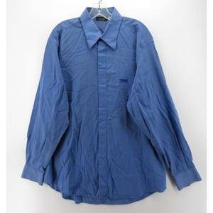 May include: A long-sleeved blue shirt with a button-down collar. The shirt has a small embroidered logo on the chest. The fabric appears to be slightly wrinkled. The shirt is hanging on a hanger against a white background.