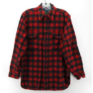 Puede incluir: Una camisa de manga larga con botones y un patr&oacute;n de cuadros rojos y negros. La camisa incluye un cuello est&aacute;ndar, una tapeta frontal con botones y dos bolsillos en el pecho con solapas abotonadas. Los pu&ntilde;os tambi&eacute;n tienen botones.