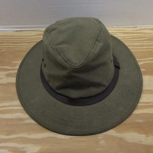 Op de afbeelding: Olijfgroene hoed met een brede rand en een donkerbruine band. De hoed heeft een gestructureerde kroon en kleine ventilatiegaten. Gemaakt van duurzame stof, geschikt voor buitenactiviteiten.