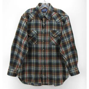 May include: A long-sleeve button-down shirt featuring a plaid pattern in shades of dark green, brown, blue, and red. The shirt includes a pointed collar, two chest pockets with buttoned flaps, and a front button closure with matching buttons.