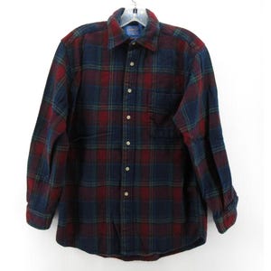 May include: A long-sleeve button-down shirt featuring a dark navy blue, deep red, and forest green plaid pattern. The shirt includes a standard collar, a single chest pocket on the left side, and light-colored buttons running down the front placket.