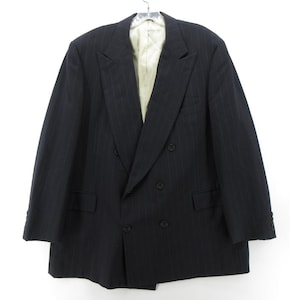 Peut inclure: Veste noire à double boutonnage avec fines rayures, suspendue à un cintre. La veste présente deux rangées de boutons, un revers cranté et deux poches avant. La doublure intérieure est beige clair.