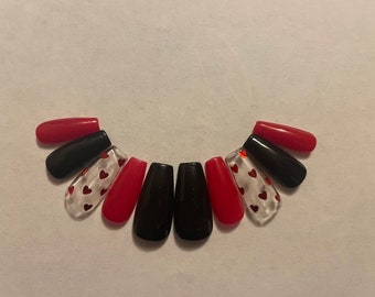 May include: Set of ten false nails with a black and red design. Some nails have a clear base with red glitter hearts.
