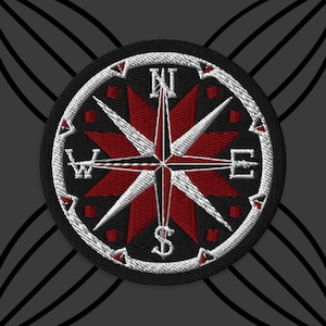May include: Embroidered patch featuring a compass rose design. The compass rose is red and white, with directional letters N, E, S, and W. The patch is circular with a black background and white border.