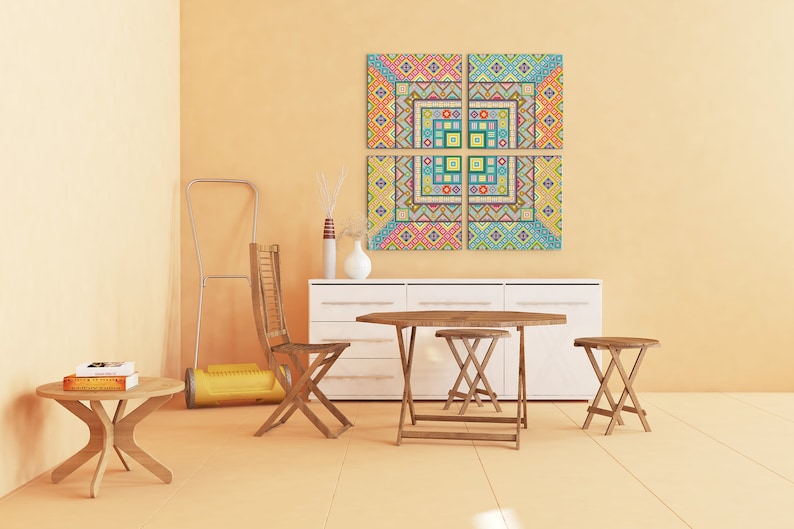 Puede incluir: Un conjunto de cuatro piezas de arte de pared de lienzo con patrones geom&eacute;tricos coloridos que cuelgan de una pared de color naranja claro sobre una c&oacute;moda blanca con una mesa y sillas de madera delante.