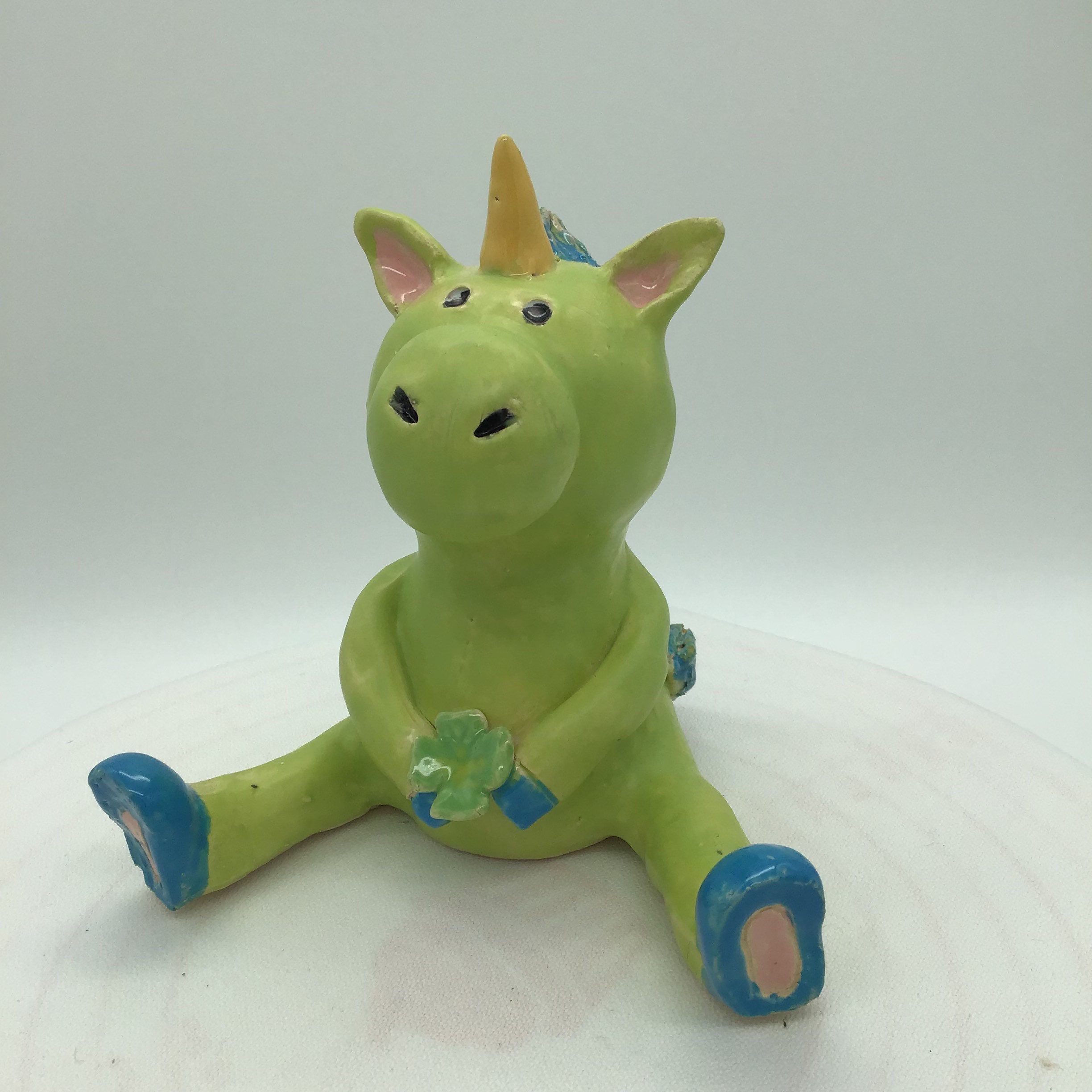 Seated unicorn in kiwi green made of ceramic