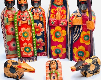 May include: A nativity scene set with hand-carved wooden figures. The set includes Mary, Joseph, the three wise men, two animals, and a baby Jesus in a manger. The figures are painted in bright colors with floral patterns.
