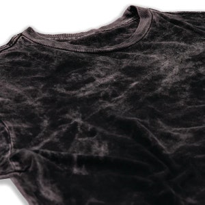 May include: A black acid wash t-shirt with a crew neck.
