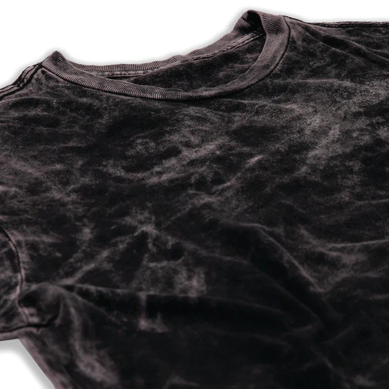 May include: A black acid wash t-shirt with a crew neck.