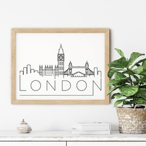 May include: A black and white line art print of the London skyline featuring Big Ben, the Houses of Parliament, and Tower Bridge. The print is framed in a light wood frame and the word "LONDON" is written below the skyline.