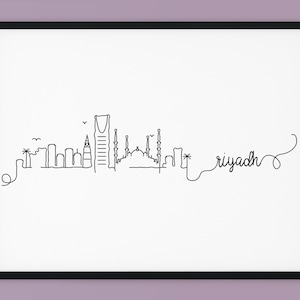 Op de afbeelding: Een zwart-witte lijntekening van de skyline van Riyad, inclusief het Kingdom Centre, de Al Faisaliah Tower en de King Fahd Library. De tekening is ingelijst in een zwart frame en geplaatst tegen een lichtpaarse achtergrond. De tekst "Riyad" is opgenomen in de tekening.