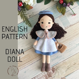 May include: Crochet pattern for a Diana doll. The doll is wearing a blue dress with a white apron, a blue hat, and brown boots. She is holding a brown basket.