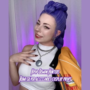 Może przedstawiać: Kobieta z niebieskimi włosami ma na sobie biały top, srebrny naszyjnik i żółto-czarną kurtkę. Obraz zawiera tekst "Kpop Demon Hunters" i "Rumi Silver Accessories Cosplay Props."