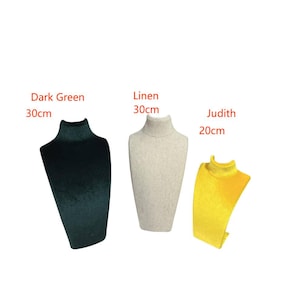 May include: Three necklace display busts in different colors and sizes. The bust on the left is dark green and 30 cm tall. The bust in the middle is linen and 30 cm tall. The bust on the right is yellow and 20 cm tall. The bust on the right is labeled "Judith".