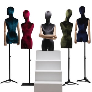 May include: Five velvet-covered mannequins on stands, each in a different color: teal, burgundy, gray, olive green, and navy blue. The mannequins are arranged in a row, with the gray mannequin on a white platform.
