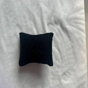 K&ouml;nnte beinhalten: Ein kleines schwarzes Samtkissen, perfekt zum Ausstellen von Schmuck oder anderen kleinen Gegenst&auml;nden.