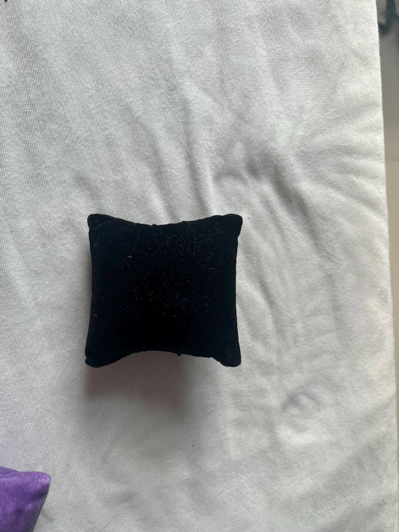 K&ouml;nnte beinhalten: Ein kleines schwarzes Samtkissen, perfekt zum Ausstellen von Schmuck oder anderen kleinen Gegenst&auml;nden.