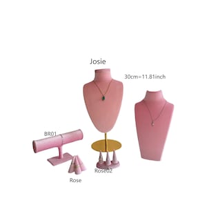 Könnte beinhalten: Rosa Samt-Schmuck-Display-Set. Enthält eine Halskettenbüste, eine Armbandstange und Ringhalter. Die Halskettenbüste ist 30 cm hoch. Das Set ist mit den Namen "Josie", "Rose" und "Rose02" beschriftet.