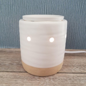 May include: A set of three ceramic mugs with a speckled, matte finish. The mugs are in shades of cream, light gray, and dark gray. Each mug has a simple, minimalist design and a rounded handle.