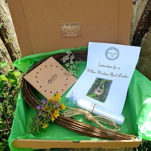 Peut inclure: Un kit d'artisanat pour fabriquer une mangeoire &agrave; oiseaux en saule pour fen&ecirc;tre. Le kit comprend des branches de saule, une base en bois avec des trous, de la ficelle, un sac en plastique transparent et des instructions. Le kit est emball&eacute; dans une bo&icirc;te en carton marron avec du papier de soie vert.