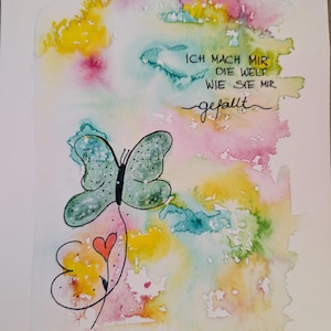 Puede incluir: Una pintura de acuarela sobre papel que presenta una mariposa verde con puntos negros y un pequeño corazón rojo. El fondo es un lavado de amarillo, rosa y verde azulado. El texto dice: ICH MACH MIR DIE WELT WIE SIE MIR gefällt. Firmado VerenaMariArt.