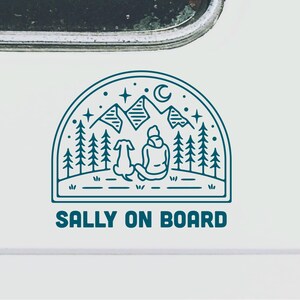 May include: A blue line art design of a person and a dog sitting in front of a mountain range with stars and a crescent moon. The text "SALLY ON BOARD" is below the design.