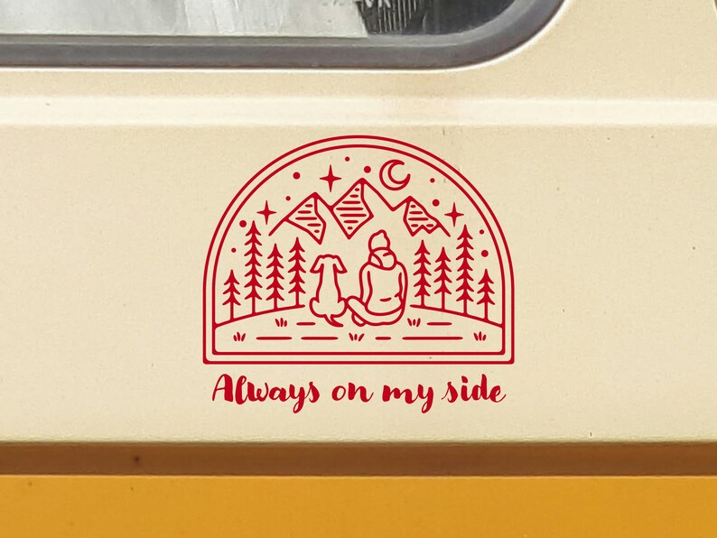 May include: Red line art sticker of a person and a dog sitting in front of a mountain range with stars and a crescent moon. The text "Always on my side" is below the image.