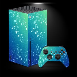 Può includere: Una console Xbox Series X e una skin per controller con un design sfumato blu e verde acqua con motivi a foglie bianche. Il controller ha pulsanti neri e un D-pad.