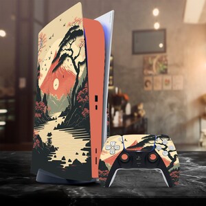 May include: A black and white PlayStation 5 console with a custom skin featuring a Japanese mountain landscape with a red sun, trees, and a river. The console is standing upright on a dark surface. A matching black and white PlayStation 5 controller is also shown on the surface.