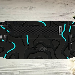 May include: Black Lenovo Legion gaming device with a textured design and bright blue neon accents. The device has the word "LEGION" printed on it.