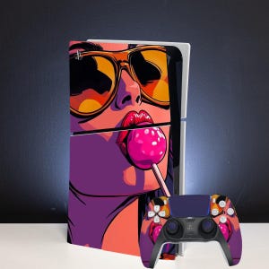 Pode incluir: Uma consola de jogos e um comando sem fios a condizer com uma capa gráfica de uma pessoa com óculos de sol grandes de tom laranja, segurando um chupa-chupa cor-de-rosa brilhante na boca, num estilo pop art vibrante com tons roxos e laranja.