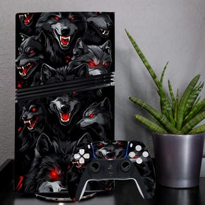 May include: A black and red PlayStation 5 console skin with a wolf design. The skin features multiple wolves with red eyes and sharp teeth. The console skin is shown on a PlayStation 5 console.