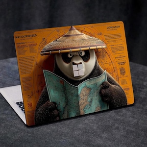 May include: A laptop with a custom skin featuring a panda wearing a straw hat and reading a map. The panda is set against a backdrop of a vintage map with text. The laptop is on a dark gray surface.