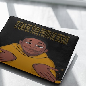 May include: A black laptop with a yellow and black design. The design features a cartoon character with the text "IT CAN BE YOUR PHOTO OR DESIGN".