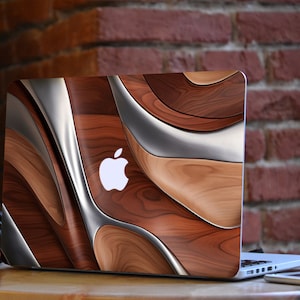 May include: A laptop computer with a wood grain and silver design skin. The Apple logo is visible on the lid.