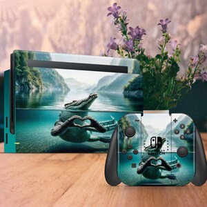 Può includere: Una skin per console e controller Nintendo Switch verde e blu con un coccodrillo con le braccia incrociate a forma di cuore. Il coccodrillo è sott'acqua in un ambiente di laguna tropicale.