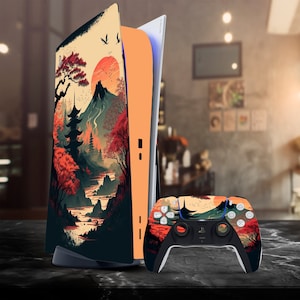 Könnte beinhalten: Eine schwarze und orangefarbene Videospielkonsole mit japanisch inspiriertem Design, das einen Berg, Bäume und eine rote Sonne zeigt. Die Konsole wird mit einem passenden schwarzen und orangen Controller geliefert.