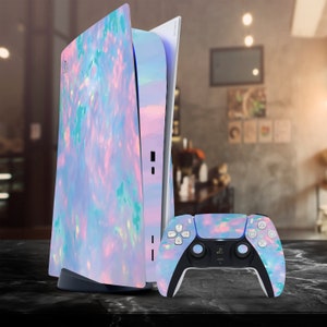 May include: A white and blue PlayStation 5 console with a custom opal-like design. The console is standing on a dark surface next to a matching controller.