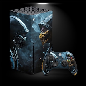 May include: A black Xbox Series X console and controller with a graphic of two armored figures with yellow masks. The console has a black top with ventilation holes and a white Xbox logo. The controller has colored buttons.