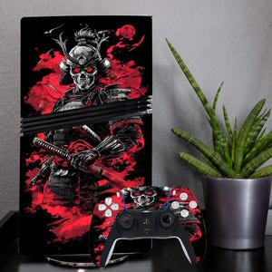 May include: A black and red PlayStation 5 console skin featuring a skull-like samurai warrior design. The skin has a red background with a black samurai warrior wearing a helmet with red eyes. The warrior is holding a katana sword. The skin is designed to fit the PlayStation 5 console and controller.
