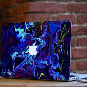 May include: A laptop computer with a blue, green, and purple abstract swirl design on the lid. The Apple logo is visible on the lid.