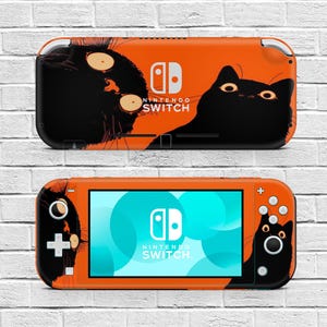 Könnte beinhalten: Orange Nintendo Switch-Konsole mit einem schwarzen Katzen-Design. Die Konsole zeigt eine schwarze Katzenillustration auf der Rückseite und an den Seiten, mit dem Nintendo Switch-Logo. Der Bildschirm zeigt eine blau-weiße Grafik.