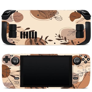 May include: A handheld gaming console featuring a beige skin with a brown botanical pattern of leaves and abstract circular shapes. The device includes a black screen, directional pad, analog sticks, and various buttons on the front and back panels.