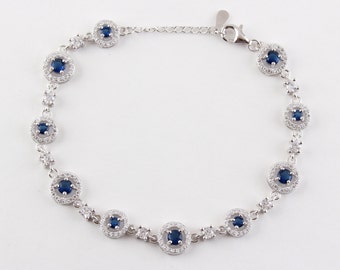 Op de afbeelding: Zilveren armband met een kettinglinkontwerp en meerdere ronde blauwe en witte edelsteenaccenten.